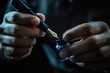 © YouraPechkin - Hand prepares fountain pen nib for inkwell with deep blue liquid in soft light