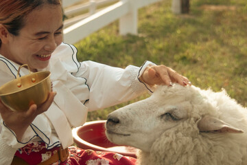 Cute little girl in traditional ukrainian folk costume with sheep