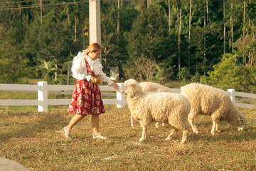 cute little girl in traditional ukrainian folk costume with sheep