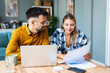 © Srdjan - Two young people, couple in relationship, working together at home office. Start up new global business, casual businessman and businesswoman work finance and economy with laptop computer and document