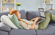 © Studio Romantic - Portrait of a serious young redhead girl wearing casual clothes using laptop lying on sofa at home, checking email or searching for friends in internet social networks or studying at home.