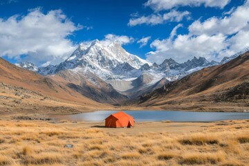 orange tent camping near lake with majestic snow capped mountain range in background
