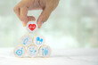 © Jintana - Hand chooses wooden toy stack with wellness medical care and healthy for family safety insurance plan or personnel sickness illness treatment concept.