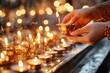 © Thanyarat - A close-up of hands lighting a candle inside a historic Jerusalem church, symbolizing faith and devotion