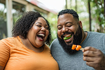 Wall Mural - couple, both plus-size, laughing while eating vegetable sticks