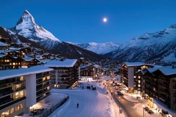 Wall Mural - A picturesque alpine village nestled under a moonlit sky, showcasing stunning architecture with snow-covered rooftops surrounded by majestic mountains lit by the moon.