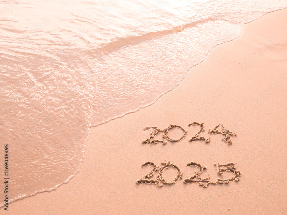 Handwritten inscription 2024 and 2025 on the beach in the sunset time ...