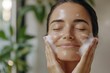 © Milos - A serene woman indulges in a refreshing facial wash, showcasing her radiant skin and a peaceful atmosphere amidst lush greenery in a calming environment.