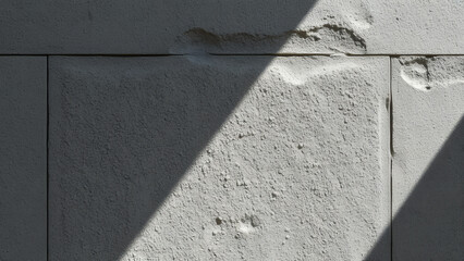 Wall Mural - Textured Concrete Wall in Light: Extreme close-up of a raw concrete wall surface illuminated by strong diagonal natural light, deep textural patterns created by aggregate and formwork impressions