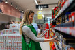 © DusanJelicic - Beautiful woman working in a supermarket. Female assistant using a digital tablet for taking inventory of products in display rack in a grocery store.