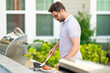 © Volodymyr - Cook at a barbecue grill preparing meat.