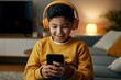 © Jenny - Hispanic young boy enjoying music on smartphone with orange headphones in cozy living room