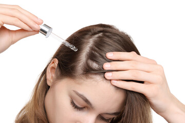 Hair loss problem. Girl applying serum onto hairline on white background, closeup