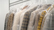 © sabyna75 - Clothing rack with garments in protective plastic in a store setting