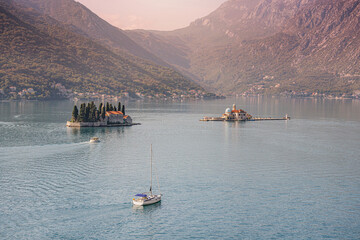 Wall Mural - Motorboats and yacht navigating bay of Kotor near the artificial islands of Our lady of the rocks church and saint George monastery