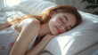 © 沈军 贡 - Beautiful young woman sleeping in bed, a happy girl resting with eyes closed on a white pillow in a home or hotel room