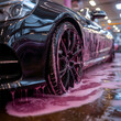 © addison - an image shows a black cars rim from that is being washed with burgundy color water and foam