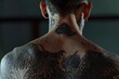 © vefimov - Man with extensive body tattoos showing intricate designs on back. Sleeveless top reveals muscle tone and unique ink patterns.