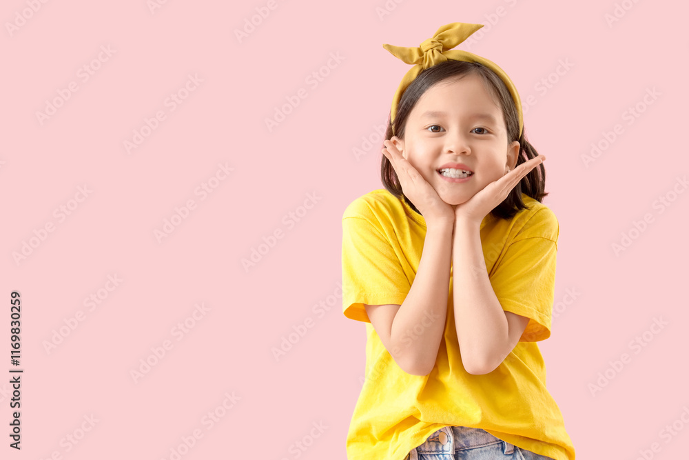 Cute little Asian girl smiling on pink background