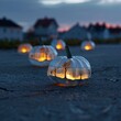 © Kan - Artistic pumpkin lanterns with surreal dreamscapes, illuminated softly in a whimsical setting.