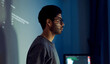 © weedezign - Indian man programmer standing in front of a screen with code projected  presentation the integration of technology and human expertise in software development
