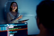 © weedezign - asian woman developers collaborating on a coding project, with one member presentation at code projected on the wall while the other works on multiple computer screens