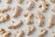 © Salman - A flat lay of ginger roots arranged in a pattern on a white background.