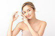 © Shutter B - Happy beautiful young Asian woman holding a cosmetic cream depicting joy and satisfaction in her skincare routine against on white background. Facial treatment, Perfect skin, Natural makeup.