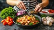 © MUHAMMADALAN - Woman preparing a healthy chicken dish with vegetables and sauces.