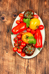 Wall Mural - Ripe tomatoes on rustic wooden background.