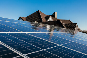 Wall Mural - Close-up of solar panels on a house rooftop with a clear sky. Utilizing photovoltaic technology for clean, renewable energy.