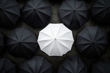 A single white umbrella standing out from the crowd of black umbrellas, symbolizing individuality and confidence in an urban setting. 