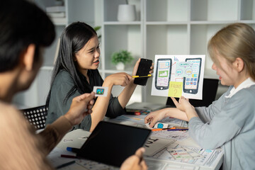 Wall Mural - creative ux ui design team brainstorming session with digital devices and wireframes in modern offic