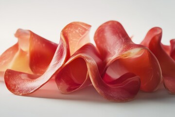 Canvas Print - Close-up of vibrant, curled slices of prosciutto on a white background.