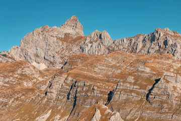 Wall Mural - Impressive mountain range with rocky peaks under a vibrant blue sky, showcasing the beauty of nature