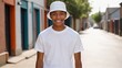 © QuoDesign - Black teenage boy wearing white t-shirt and white bucket hat standing in a city alley