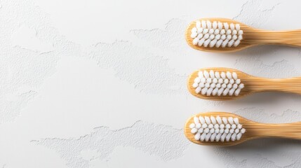 Wall Mural - Three wooden toothbrushes with white bristles on a gray background