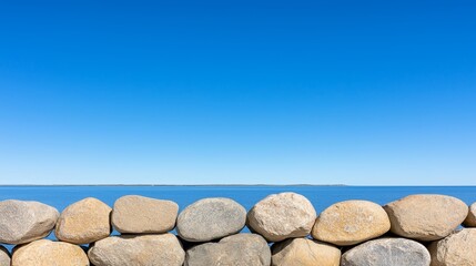 Poster - A large pile of rocks sitting on top of a beach next to the ocean