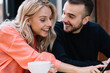 © BullRun - Happy couple in love having fun on leisure laughing at funny photo on smartphone sitting in cafe,cheerful young caucasian woman and man enjoying news from social networks talking using mobile phone