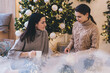 © BullRun - Calm young ladies opening Christmas presents