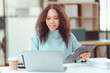 © ArLawKa - Beautiful African girl sitting at the table Looking at the laptop screen, he looks happy reading an email message with good news. Chat with customers online