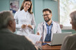 © Goran - Happy doctors talking with their patients while having an appointment in the office.