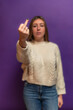 © EDER - vertical Young woman showing middle finger on purple background