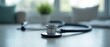 © Viktor_D - Stethoscope on a table, with blurred background featuring medical tools.