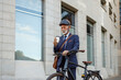 © Moon Safari - Serious male entrepreneur holding coffee cup and pushing his bicycle on city street in the morning