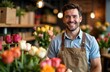 © ilyaska - Florist smiling in flower shop surrounded by colorful roses and tulips