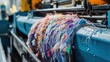 © Justlight - Close up view of textile waste being processed by an industrial recycling machine, transforming discarded colorful fabric scraps into reusable material for sustainable production