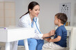 © Pixel-Shot - Female pediatrician with stethoscope listening to cute little boy at table in clinic