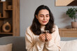 © Pixel-Shot - Beautiful young happy woman with cup of hot chocolate sitting on sofa at home