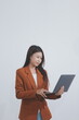 © Sirikarn Rinruesee - Attractive smiling Asian businesswoman standing holding tablet working and recording work details in office.